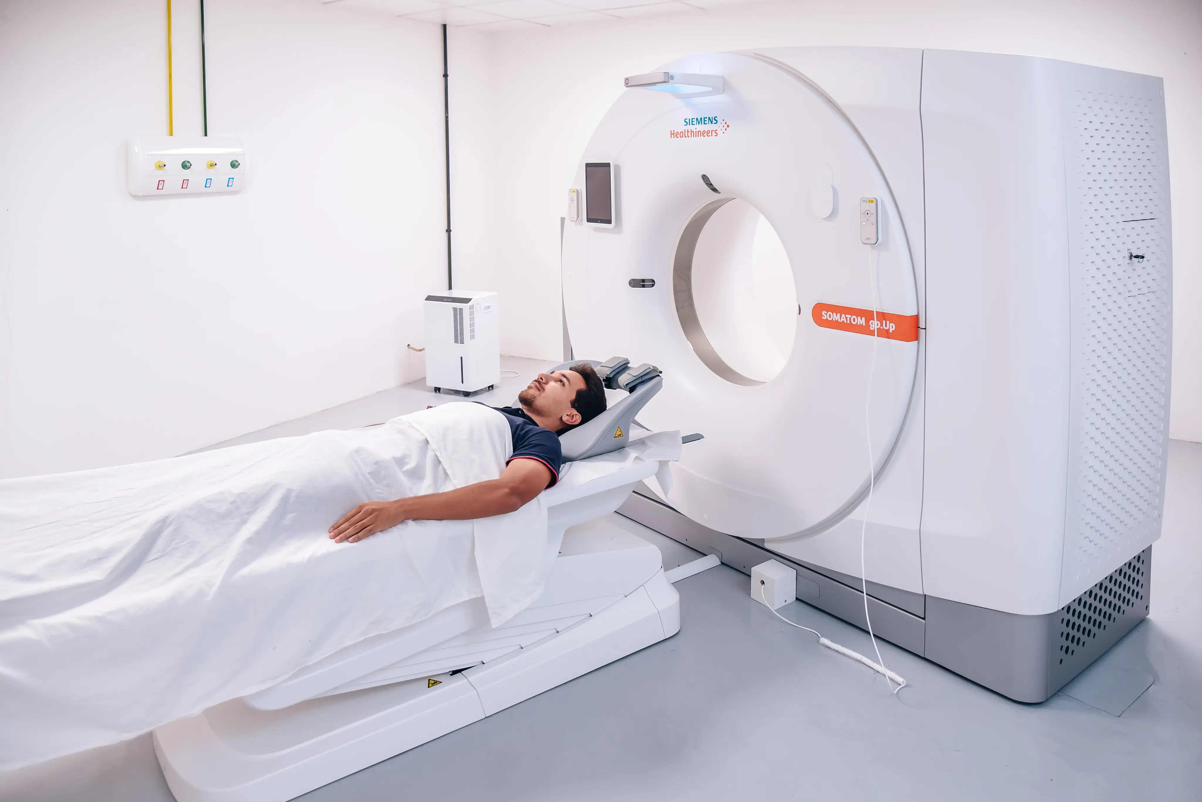 Paciente posicionado em equipamento de tomografia computadorizada